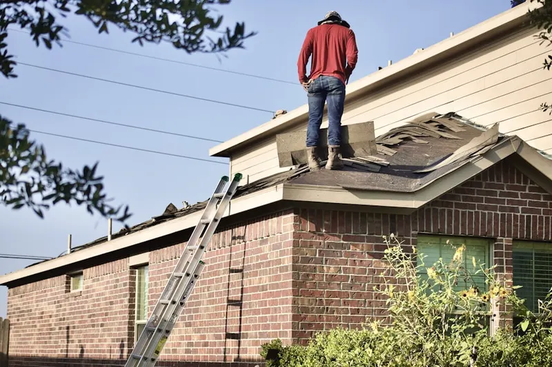 Professional roofer working on a residential roof in Red Mill